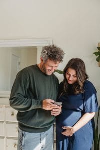 A pregnant couple researching doula support together